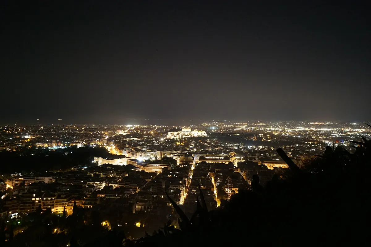 Athens at night from Lycabettus hill, with the lit Acropolis in the middle of the city.