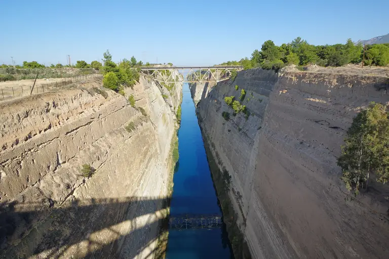 The Corinth Canal, cut through the rock of the isthmus, with a bridge crossing it.