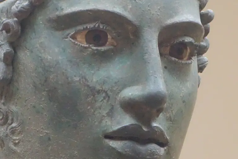 The bronze face of the Charioteer of Delphi, with its inlaid eyes, in the Delphi museum.