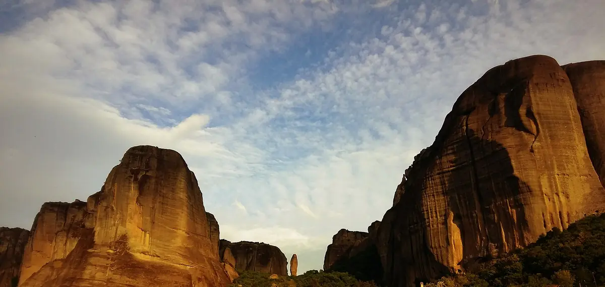 The rock pillars above Kastraki lit orange by the evening sun.