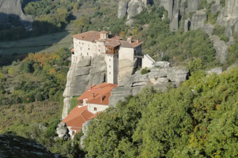 The monastery of Rousanou on its narrow rock, with the pillars of Meteora behind.