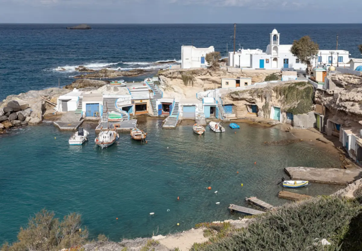 The fishing village of Mandrakia on Milos, with boathouses cut into the rock at the water.