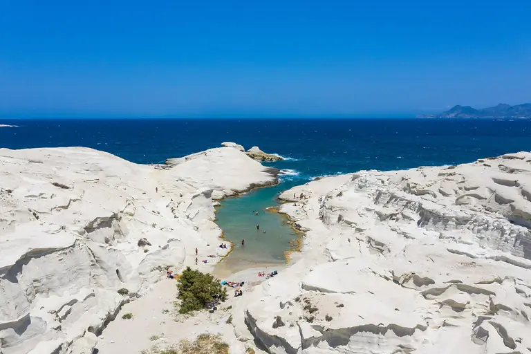 The white volcanic rock of Sarakiniko on Milos, seen from above, with the sea beyond.