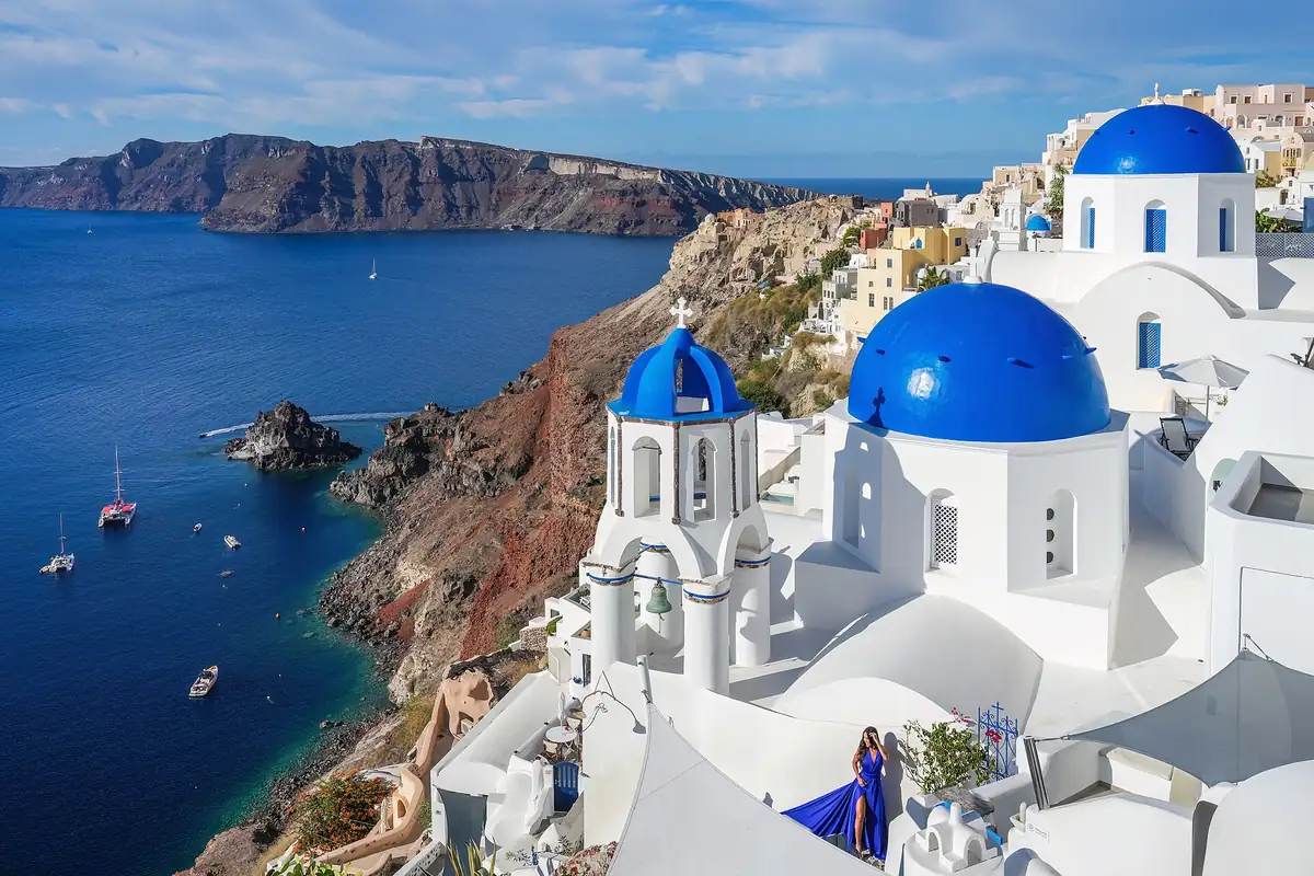 Three blue church domes in Oia, Santorini, above the caldera.