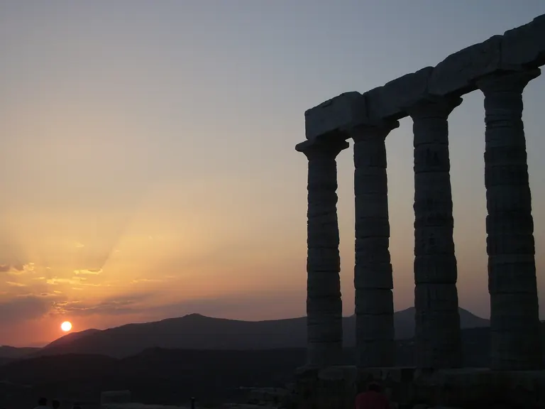 The columns of the Temple of Poseidon at Cape Sounion against the sunset.